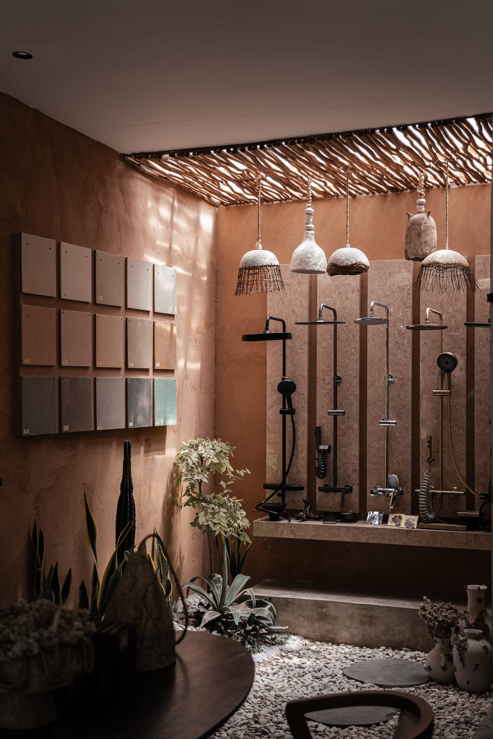 Rustic-modern display of shower fixtures and wall finishes under a slatted canopy.