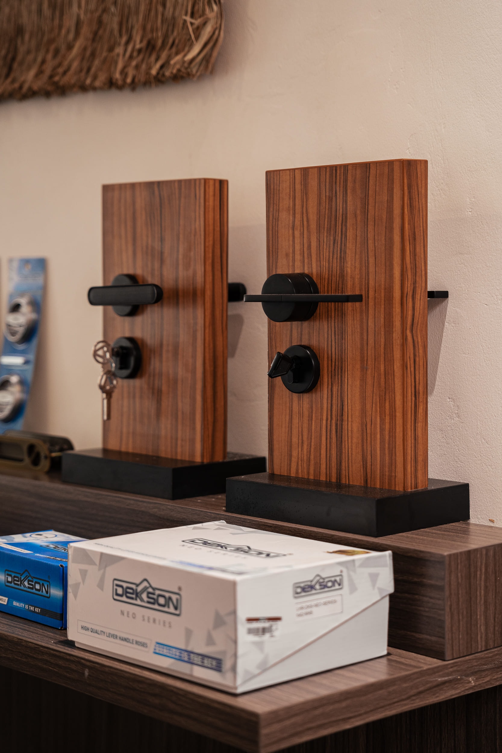 Modern black door handles mounted on wooden display blocks.