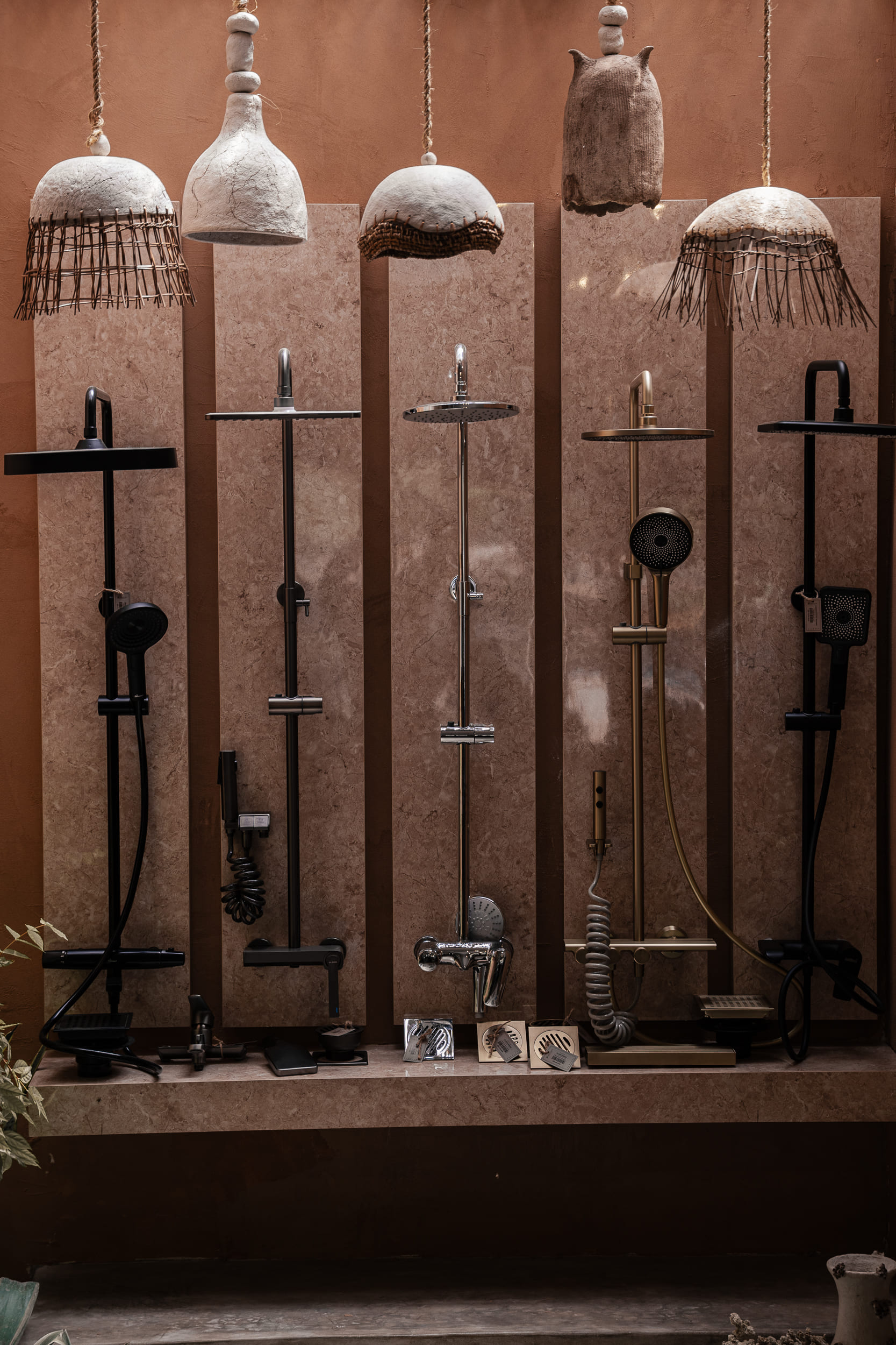 Display of luxury shower heads and fixtures on vertical marble panels.