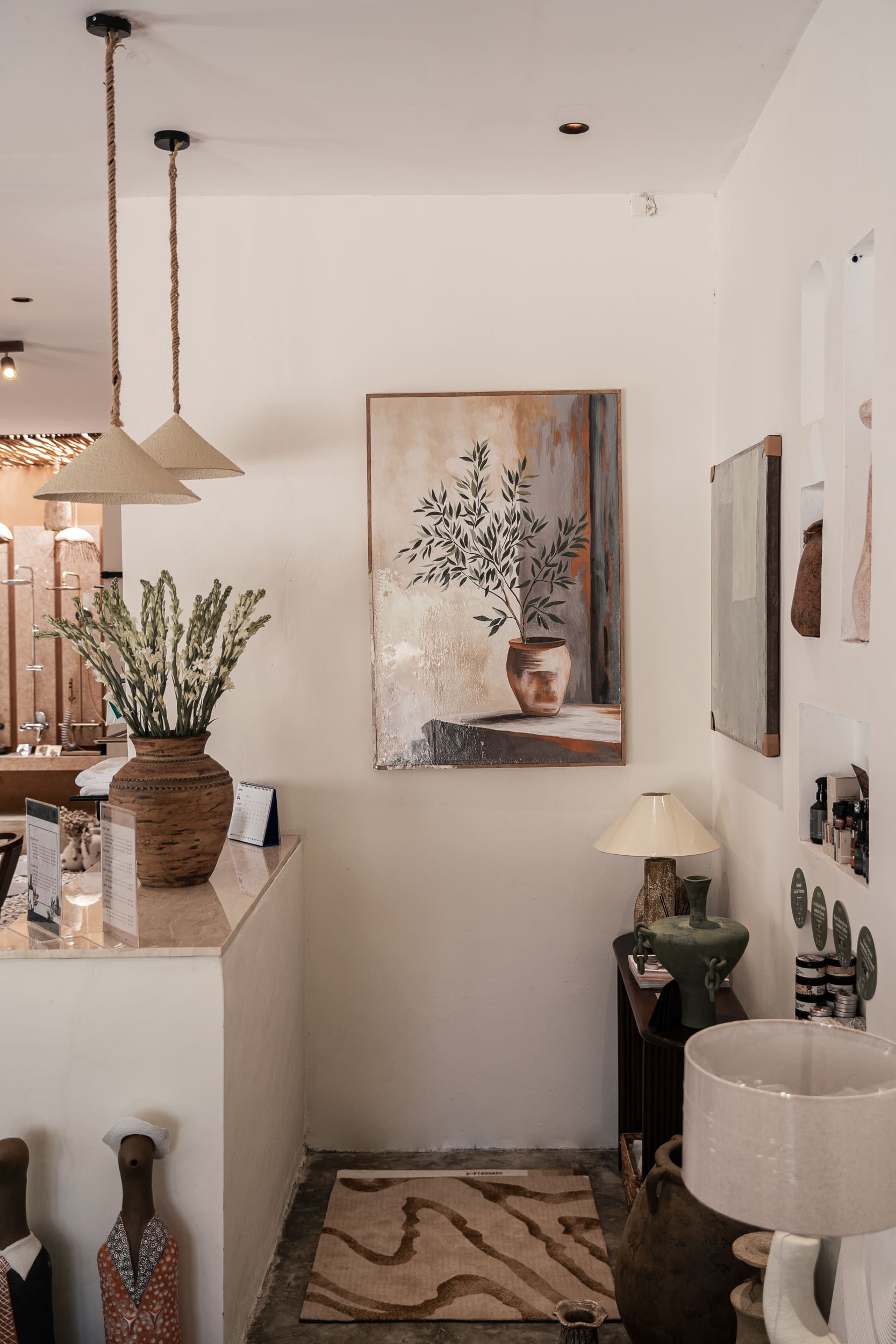 Artisanal corner with reception counter, pendant lights, and decorative objects.