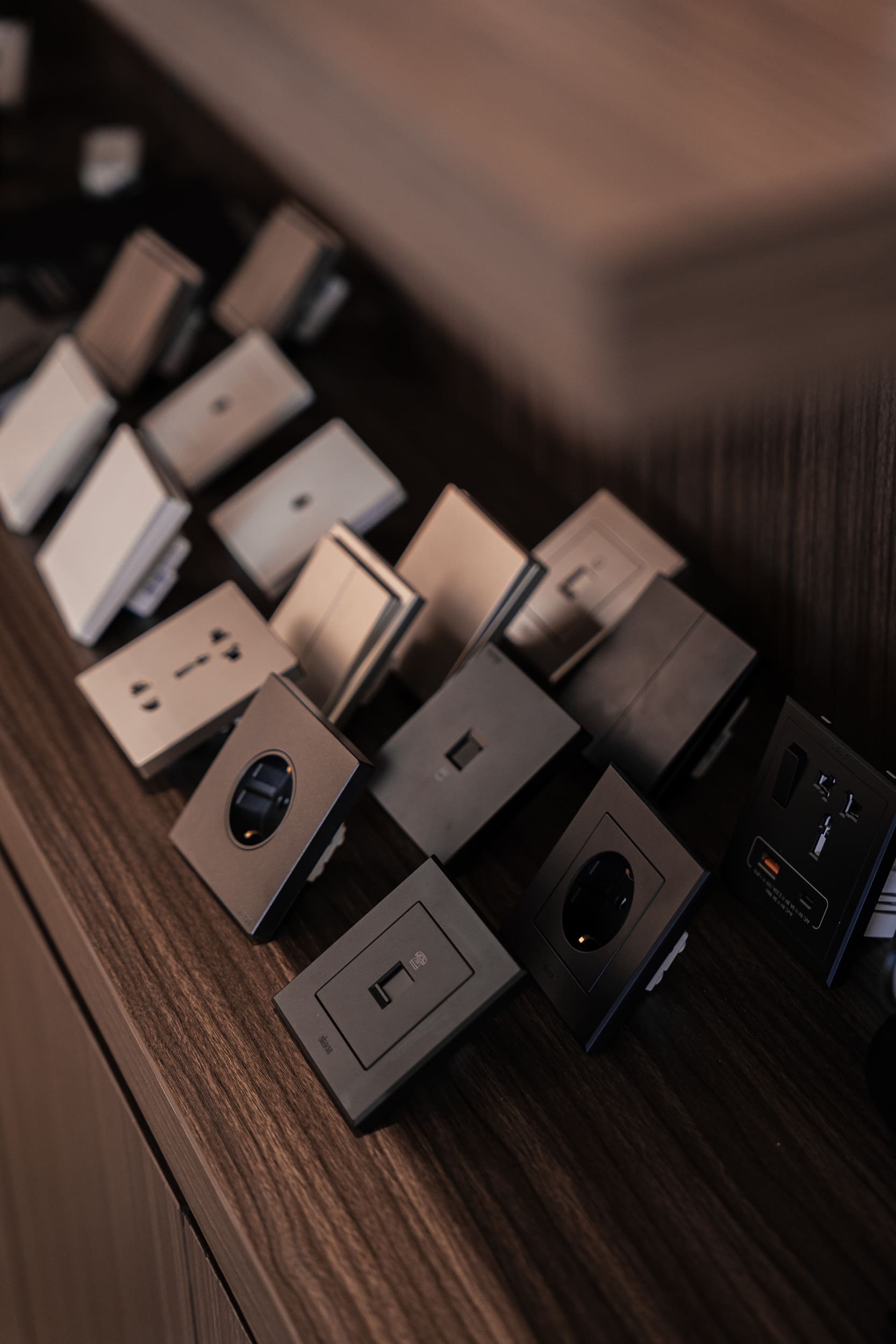 Premium electrical switches and wall sockets displayed on a wooden shelf.