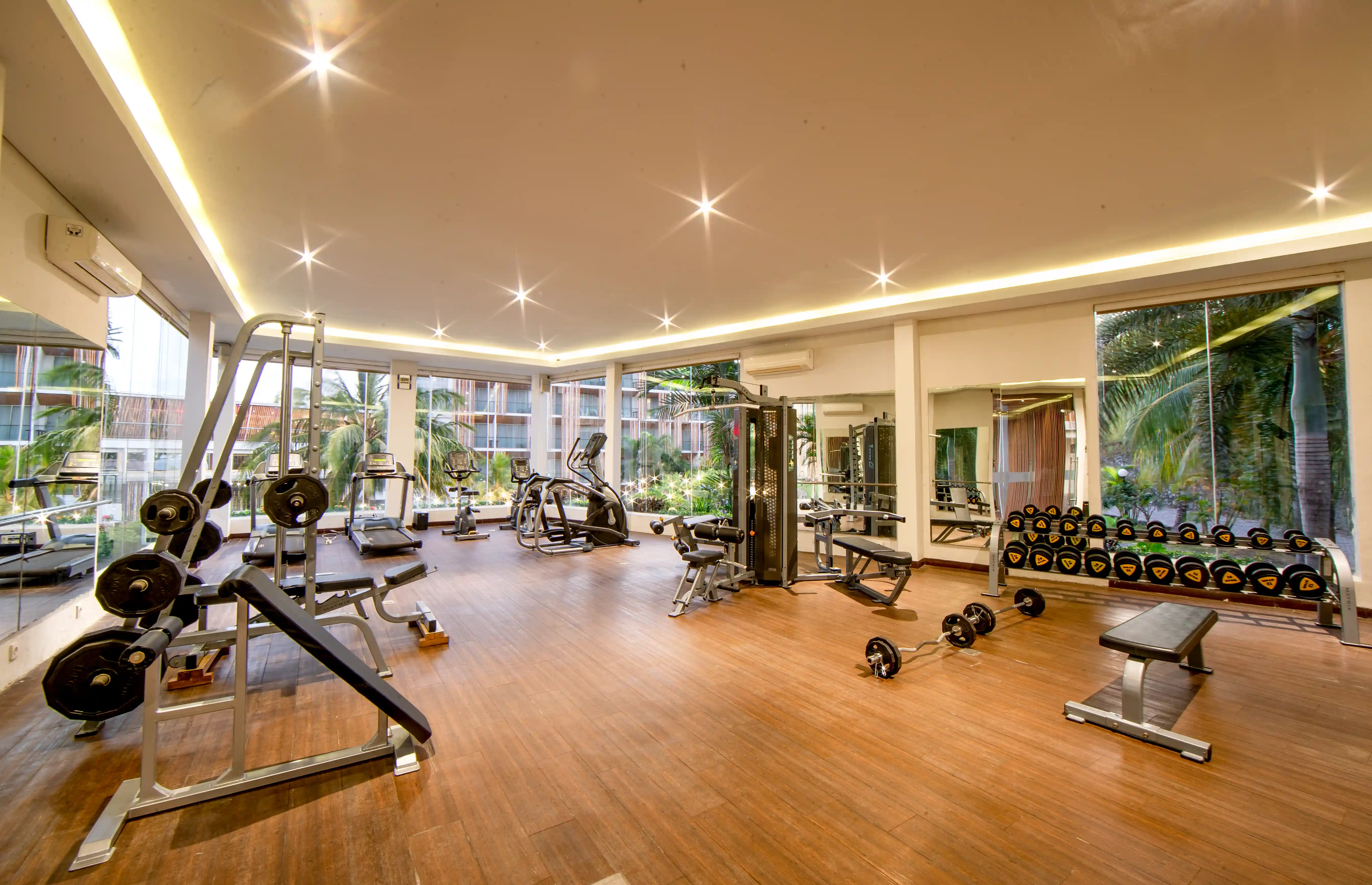 Bright and modern gym equipped with weight machines, treadmills, and free weights.