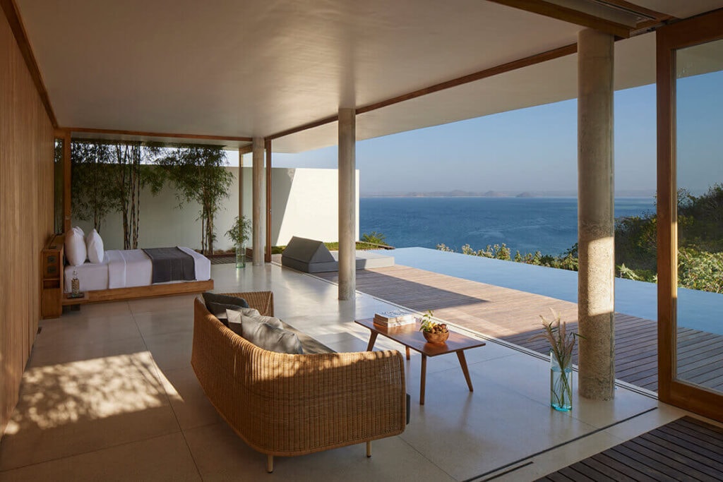 Open-air luxury villa suite overlooking an infinity pool and ocean.