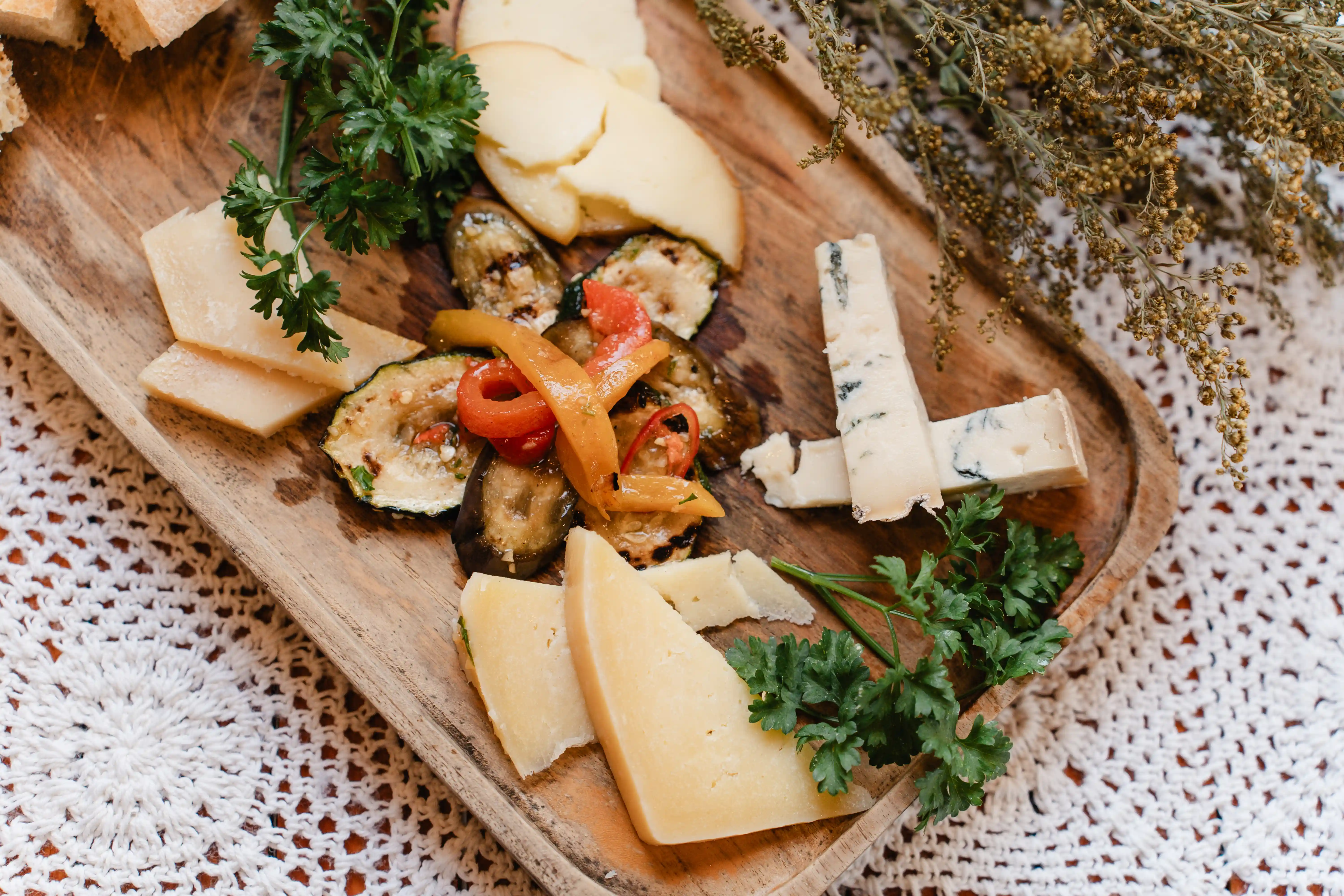 Cheese and grilled vegetable platter served on a wooden board.