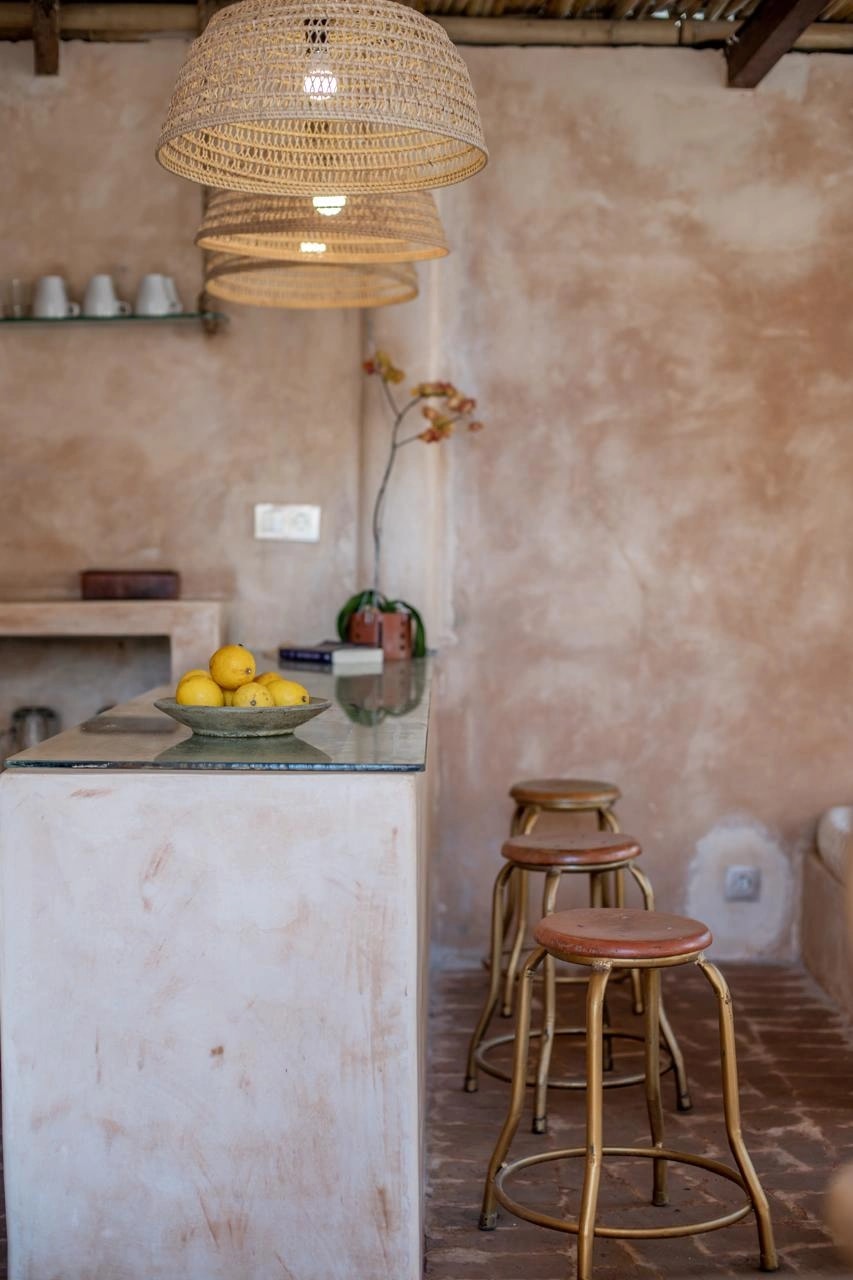 Comptoir de bar en béton avec tabourets en bois et coupe de citrons.